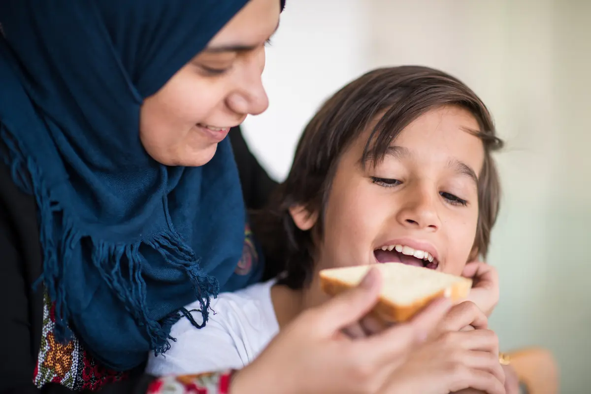 Mother trying to feed a kid with pediatric feeding and swallowing difficulties
